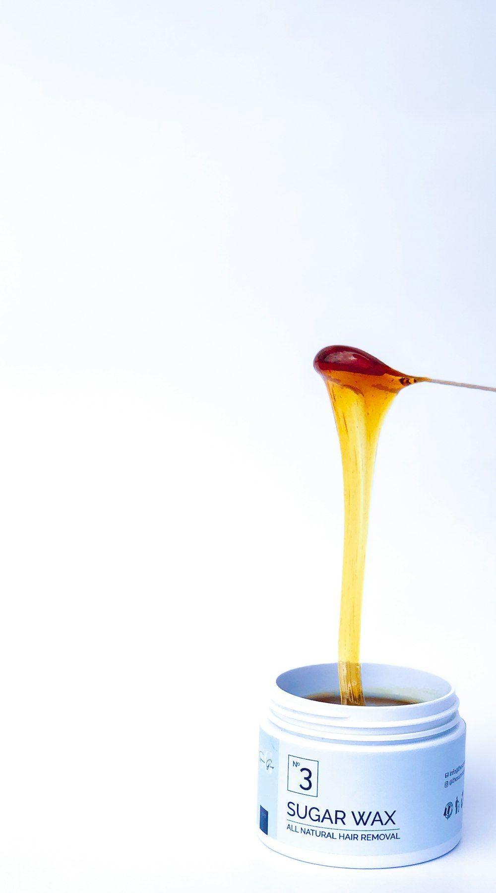 Warm wax on a spatula during a professional waxing treatment
